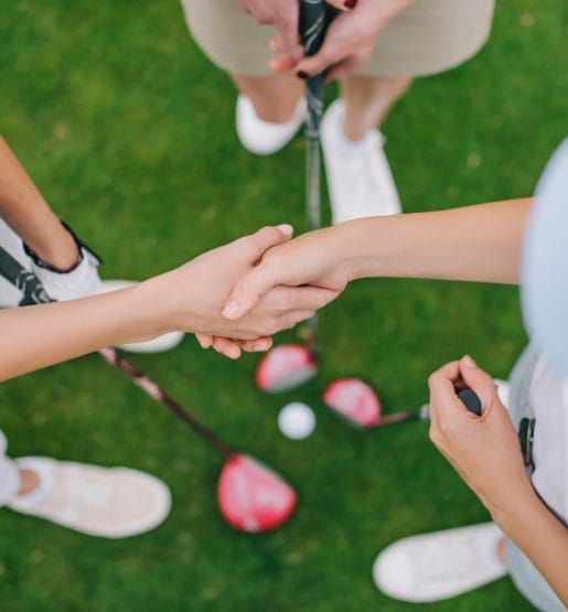 Overhead view of female golfers shaking hands Overhead view of female preferred players shaking hands